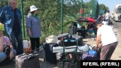 Zeci de ucraineni care speră să își viziteze casele din zonele ocupate de Rusia sunt blocați în țara nimănui în timp ce așteaptă autorizația de intrare.