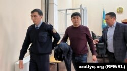 "Алаяқтық жасады" деген күдікке ілінген заңгер Өтепов (ортада) сотта. Орал, 24 наурыз, 2023 жыл.