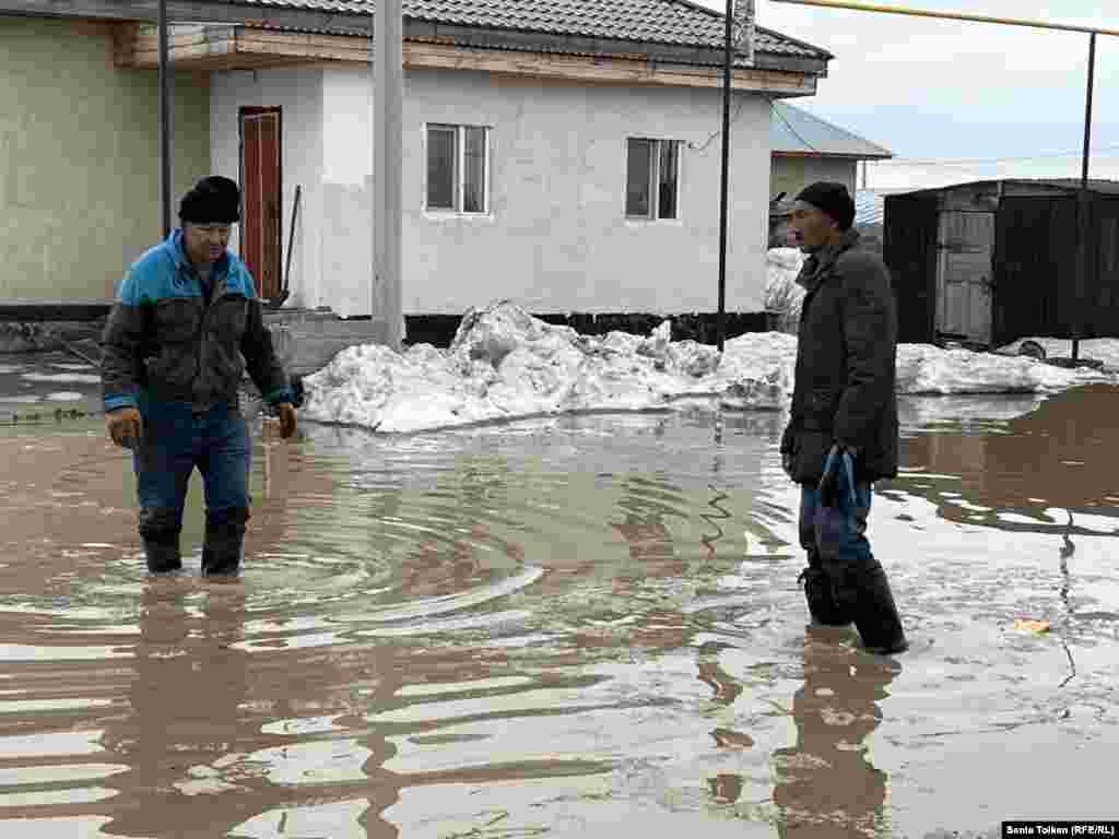 Қарғын су басқан үйдің ауласында тұрған адамдар. Астананың іргесіндегі Қоянды ауылында тұрғындардың тасқын сумен алысып жатқанына бірнеше күн болды. 27 наурыз, 2024 жыл. Тасқын салдарын жоюда биліктің шарасыздығына наразы болған тұрғындар көшеге шығып, жолды жапты. Билік алты адамға "заңсыз митингіге қатысқаны" үшін айыппұл салды.