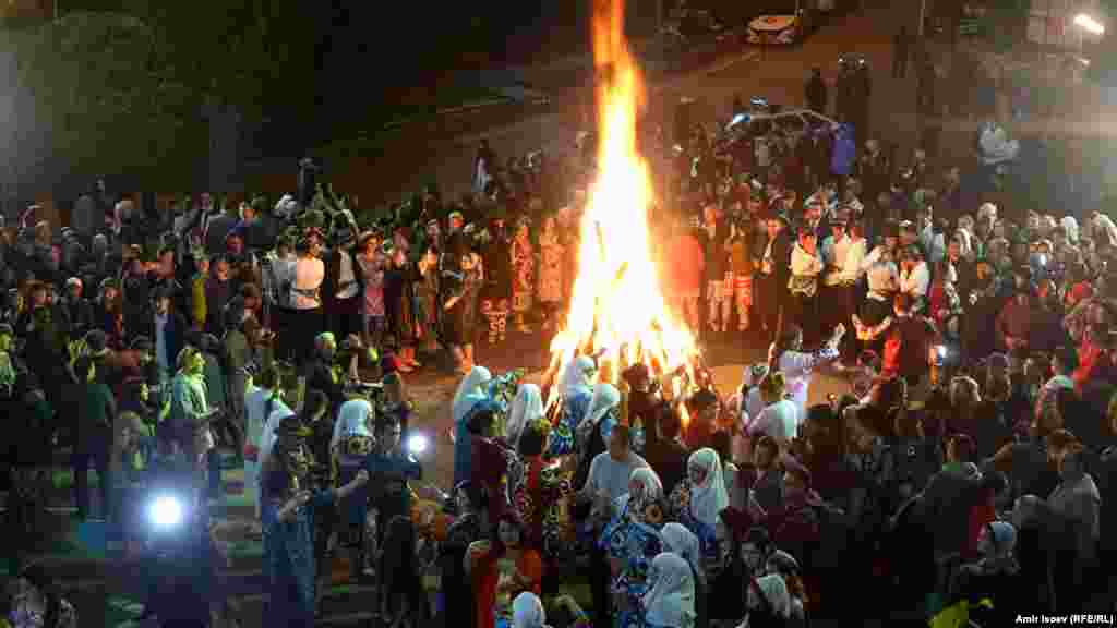 People dance and sing around a large bonfire in Dushanbe. 