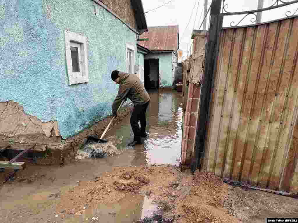 Қоянды ауылының тұрғыны Аягөз Түгелованың үйінің ауласына кірген қарғын суды шығарып жатқан адам. 27 наурыз, 2024 жыл.