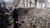 Чоловік в Авдіївці оглядає свіжу вирву в центрі його рідного міста після російського обстрілу. Фото: Якуб Лайхтер (©)
