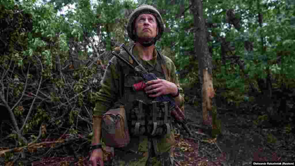 Un soldat ucrainean scrutează cerul în căutarea dronelor inamice în apropierea poziției sale de lângă Ceasiv Iar. „Astăzi, soldații noștri au avansat în toate direcțiile; este o zi fericită. Le doresc băieților mai multe zile ca aceasta", a declarat Zelenski.