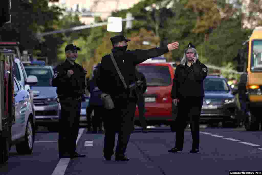 Ofițerii de poliție securizează o zonă din afara unei clădiri nerezidențiale deteriorate de pe Komsomolski Prospekt după un atac cu dronă.