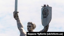 Робітники під час підготовки до демонтажу герба СРСР зі щита монумента «Батьківщина-мати», замість якого встановлять Тризуб – герб України. Київ, 24 липня 2023 року