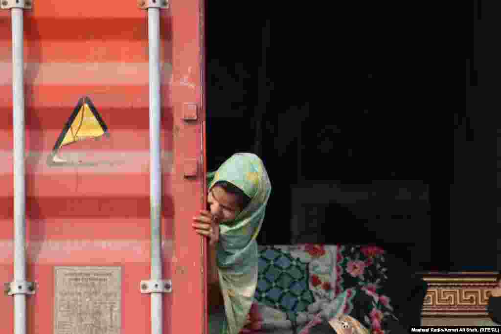 Një vajzë e re duke shikuar nga pjesa e pasme e një kontejneri mallrash. Më 3 tetor, Ministria e Brendshme pakistaneze njoftoi se të gjithë emigrantët pa dokumente në Pakistan, duhej të largoheshin nga vendi brenda 28 ditëve. Që nga 27 tetori, rreth 60.000 afganë ishin larguar nga Pakistani, njoftuan Kombet e Bashkuara. Shumë prej tyre përmendën frikën nga arrestimi në Pakistan si arsyen kryesore të kthimit.