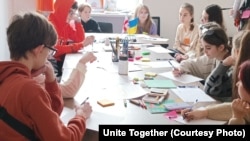 Copii ucraineni pictează în timpul unei activități organizate de ONG-ul Unite Together, februarie 2023.