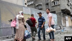 Banorë palestinezë duke u zhvendosur pas sulmeve ajrore izraelite në qytetin e Gazës, 9 tetor 2023.
