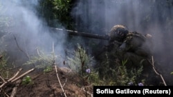 Un soldat ucrainean trage cu un lansator de grenade antitanc pe linia frontului, lângă orașul Bahmut, regiunea Donețk, pe 13 iulie.