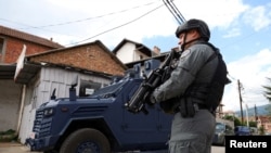 Një pjesëtar i njësisë speciale të Policisë së Kosovës në gatishmëri, pas arrestimit të një personi të identifikuar si organizator i protestave të dhunshme të muajit maj, në Mitrovicën e Veriut, Kosovë, më 13 qershor 2023.