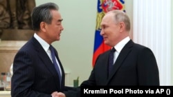 Голова канцелярії Комісії з закордонних справ Центрального комітету Комуністичної партії Китаю Ван Ї (ліворуч) і президент Росії Володимир Путін. Москва, 22 лютого 2023 року
