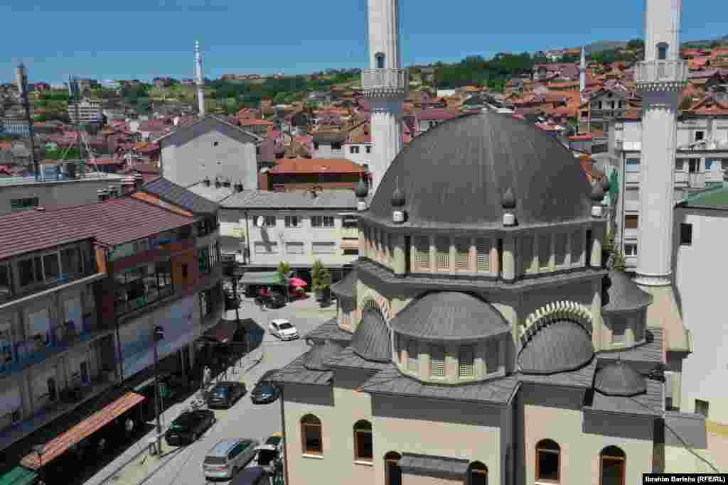Rahovec 10 korrik 1999: Në këtë fotografi të publikuar nga Reuters, shihen mijëra qytetarë shqiptarë të Rahovecit derisa protestojnë kundër mundësisë që për sigurinë e tyre të kujdesen trupat ruse që kishin hyrë në Kosovë pa një koordinim me NATO-n. 6 qershor 2024: Sheshi në të cilin u zhvillua protesta, sot ka një pamje krejtësisht tjetër. Një xhami e madhe dhe shumë objekte të reja.