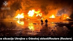 Пожежники працюють на території порту на річці Дунай, який постраждав від удару російського безпілотника, 6 жовтня 2023 року