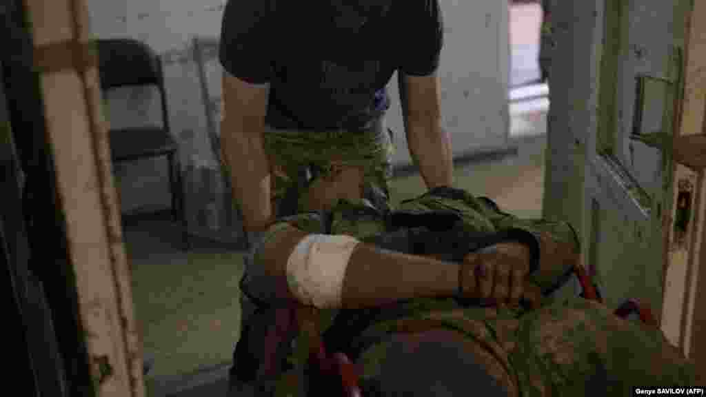 Un medic ucrainean transportă un soldat rănit la un punct de stabilizare de lângă Bahmut. Ambele părți au refuzat să dezvăluie statistici privind victimele războiului.
