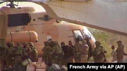 Mercenarët rusë duke hipur në një helikopter në veri të Malit.