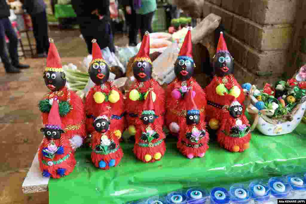 Figures of the fictional folklore character Hajji Firuz, who appears in the streets at the beginning of Norouz, are displayed at a stall in Tehran ahead of the festival. 
