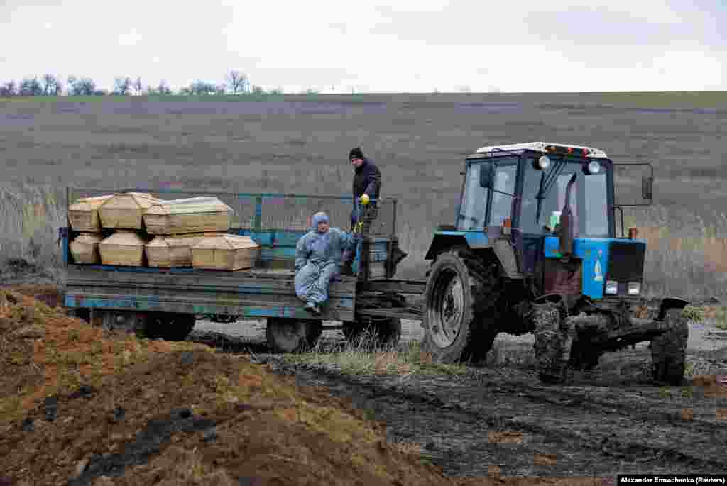 Groparii transportă sicrie la un cimitir de la periferia orașului Mariupol. Se pare că trupurile civililor au fost descoperite printre dărâmăturile clădirilor mult timp după ce asediul rusesc s-a încheiat. Mulți civili s-au adăpostit de lupte în subsolurile blocurilor de locuințe.
