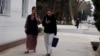 Mobile telefonda gürleşip we oňa seredip barýan zenanlar (Illýustrasiýa suraty)