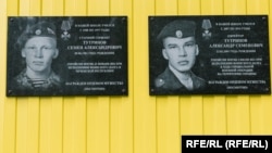 Emléktáblák a kuratovói iskolában, ahol Szemjon (balra) és Alekszandr Tutrinov is tanult