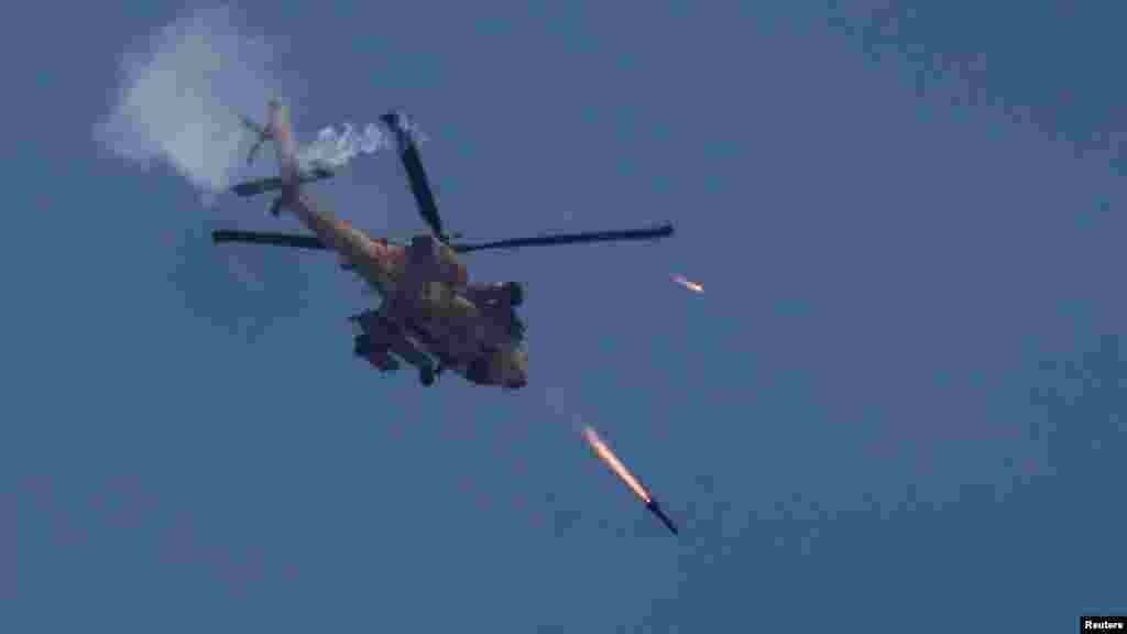 Egy izraeli katonai Apache helikopterrakétákat lő ki Gáza felé 2024. május 14-én. Az izraeli hadsereg szerint „több terroristát is likvidáltak”, alagútaknákat lokalizáltak, valamint kilövőállásokat és egy fegyverraktárat számoltak fel a Gázaváros keleti részén fekvő Zeitún körzetében