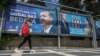 Një grua kalon pranë posterëve të presidentit aktual, Recep Tayyip Erdogan, dhe kundërkandidatit të tij, Kemal Kilicdaroglu. Sanliurfa, 28 prill 2023.