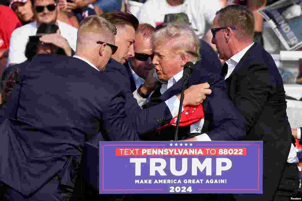 Donald Trump republikánus elnökjelöltet és volt amerikai elnököt testőrök fogják közre, miután rálőttek a pennsylvaniai Butlerben 2024. július 13-án