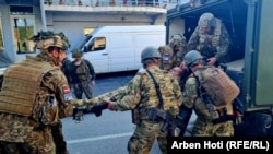 Pripadnici KFOR-a unose povređenog u sukobima sukoba sa lokalnim Srbima ispred zgrade Opštine u Zvečanu, Kosovo, 29. maja 2023.