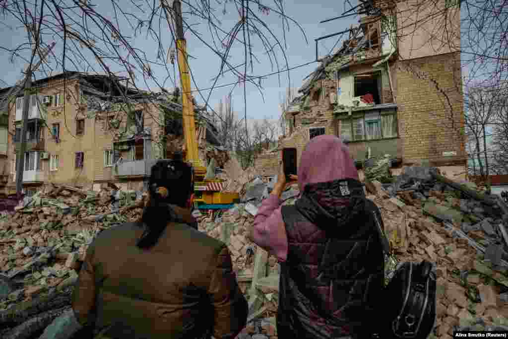 Місцеві жителі фотографують наслідки ракетного удару по житловому будинку в місті Селидове на сході України. Місцева влада повідомила, що в результаті російської атаки загинули щонайменше двоє людей, у тому числі 85-річна жінка. 15 листопада 2023 року