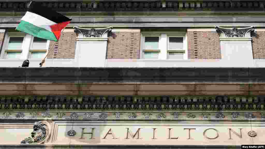 Egy diák palesztin zászlót tart a New York-i Columbia Egyetem erkélyén. A rendőrök egy második emeleti ablakon keresztül másztak be a Hamilton Hallba, hogy letartóztassák a diákokat