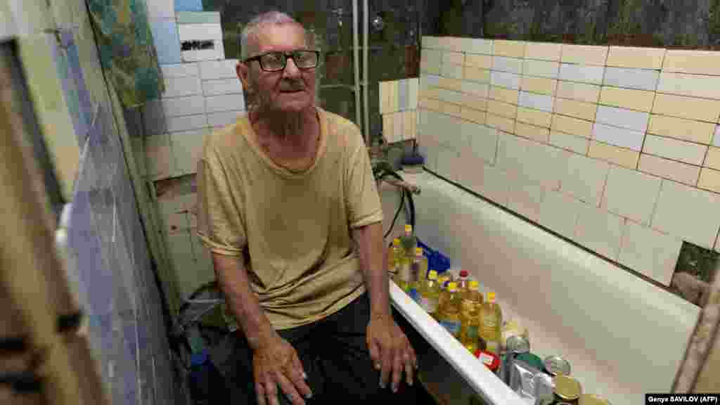 Viktor Grozdov, în vârstă de 77 de ani, în baia casei sale avariate, pe 28 iunie, în orașul Avdiivka situat în estul Ucrainei. Baia a devenit refugiul său atunci când plouă cu obuze de artilerie afară. Suburbie a orașului Donețk, Avdiivka este bombardat de până la 30 de ori pe zi. „În ultimele aproximativ patru luni, nu a existat nicio zi fără atacuri aeriene sau cu rachete", a declarat pentru AFP Vitali Barabaș, șeful administrației militare.