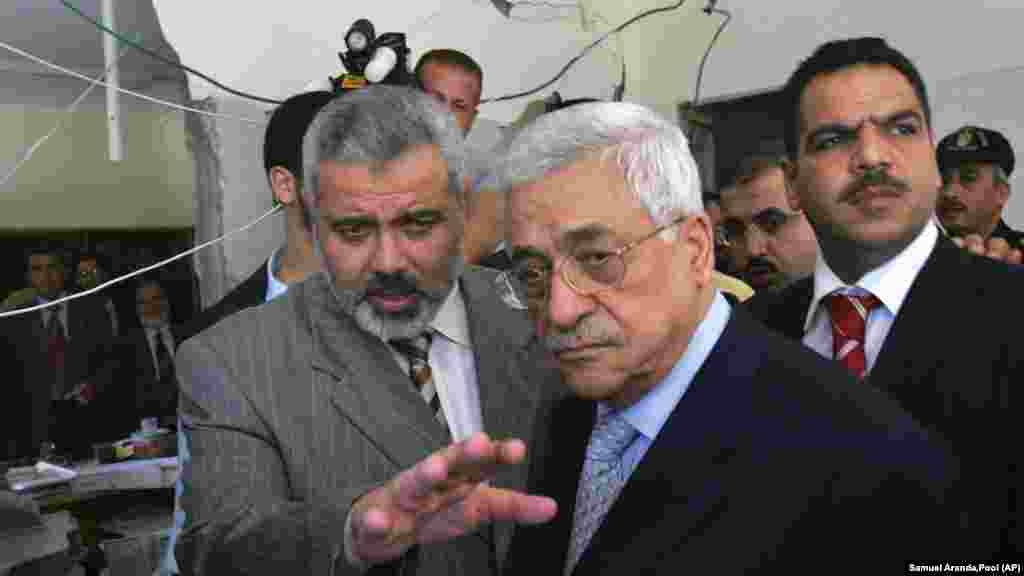 اسماعیل هنیه در کنار محمود عباس، رئیس تشکیلات خودگردان فلسطینی (راست)، حین بازدید از اتاقی در ساختمان شورای وزیران غزه که دفتر هنیه نیز در آن‌جا بود و دوم ژوئیه ۲۰۰۶ هدف حملۀ هوایی اسرائیل قرار گرفت.