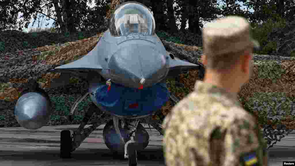 Egy ukrán katona szemléli az egyik frissen érkezett F–16-os harci repülőgépet egy meg nem nevezett ukrajnai légi bázison