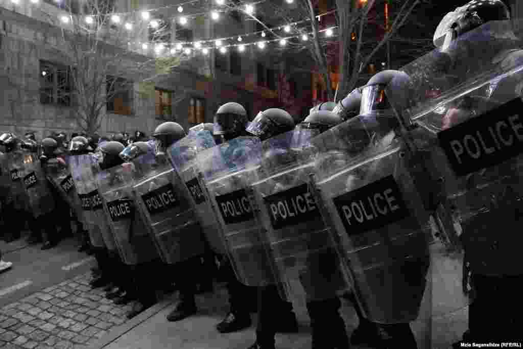 Poliția antirevoltă se aliniază pentru a forța protestatarii să se îndepărteze de parlament.