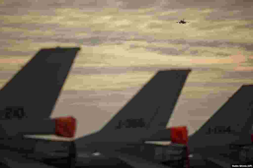 Avion de vânătoare F-16 al Forțelor Aeriene Române zburând deasupra bazei aeriene. România, care este membră NATO din 2004, și-a sporit cheltuielile pentru apărare, iar NATO și-a consolidat prezența pe flancul estic al Europei prin trimiterea de grupuri de luptă multinaționale suplimentare în România, Ungaria, Bulgaria și Slovacia, membre ale alianței. 