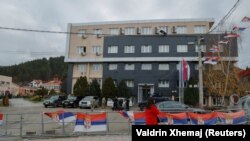 Një grua duke ecur para ndërtesës komunale në komunën e Leposaviqit, në veri të Kosovës, më 8 dhjetor 2023.