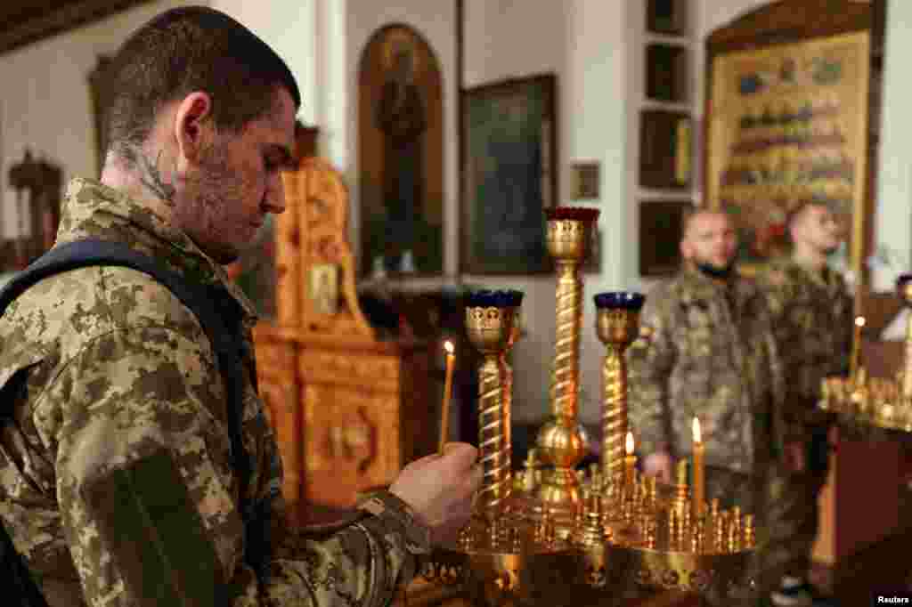 Украински војници се молат во православна црква за време на Велигден во Слованск, во близина на линијата на фронтот во регионот Источен Донецк, на 24 април.