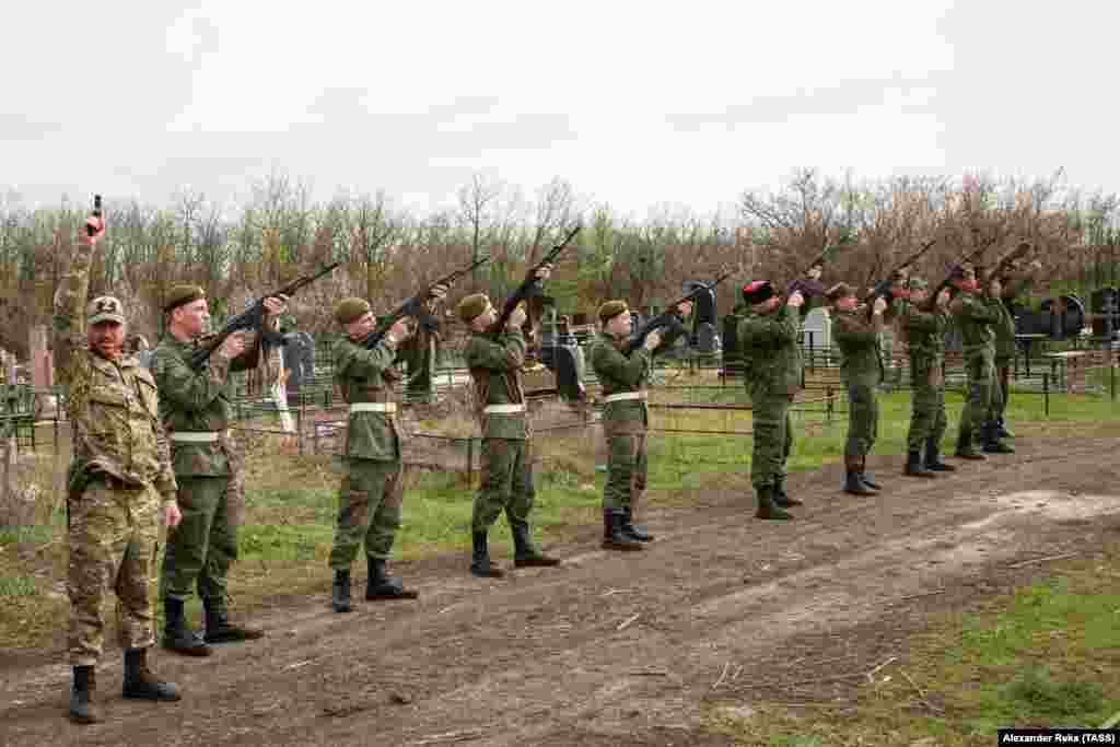Сепаратистичките борци од регионот Луганск, поддржани од Русија, упатуваат поздрав за време на погребот на командант на 19 април.