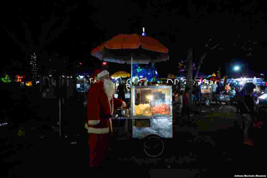 Një shitës pupagjelash i është bahskuar atmosferës festive duke u veshur si Babadimër, Brazil 11 dhjetor 2024. 