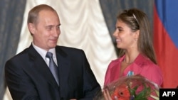 Владимир Путин көркем гимнастика бойынша Олимпиада чемпионы Алина Кабаеваны орденмен марапаттап, гүл беріп жатыр. 8 маусым 2001 жыл.