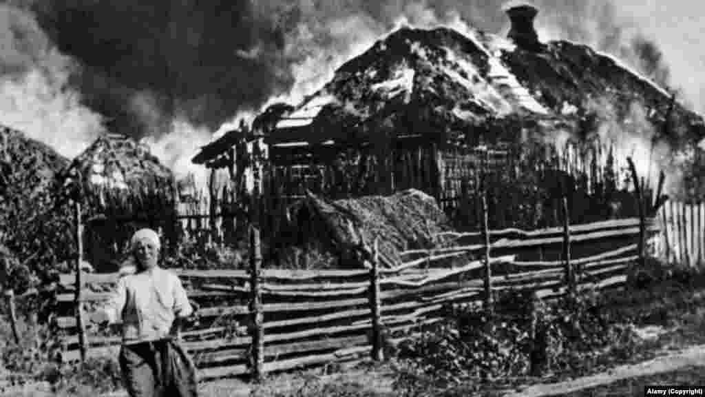 Egy asszony sír lángokban álló háza előtt a Szovjetunió 1943-as náci megszállása alatt – Irpinyi háza előtt sír egy nő, akinek találat érte otthonát, amely kigyulladt 2022. március 4-én