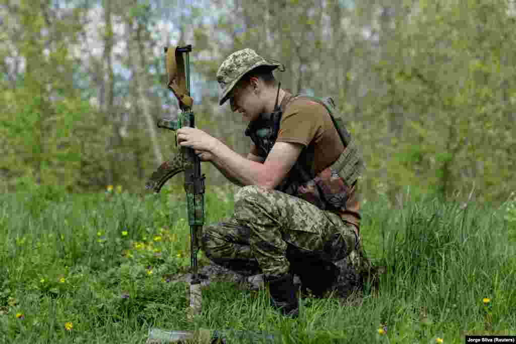 A Ukrainian fighter cleans his rifle while on duty near the front line in Svyatohirsk on April 27. 