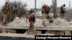 Militari ucraineni construiesc un buncăr în timpul bombardamentelor intense de la Bahmut, 26 decembrie 2022.
