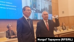 Жигули Дайрабаев ОСК берген "Қазақстан президенттігіне кандидат" куәлігін көрсетіп тұр