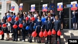 Elevii participă la o ceremonie de Ziua Științei care marchează începutul noului an școlar la o școală din satul siberian Verh-Cita, pe 1 septembrie 2022.