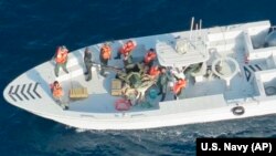 Foto e publikuar nga Departamenti amerikan i Mbrojtjes, ku sipas Marinës amerikane, shfaqen trupat e Gardës Revolucionare të Iranit, duke larguar një minë të pashpërthyer nga cisterna e naftës.