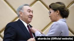 Дариға Назарбаева (оң жақта) әкесі Нұрсұлтан Назарбаевқа "құрметті сенатор" төс белгісін тапсырып тұр. 6 маусым 2019 жыл.