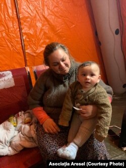 O mamă refugiată de etnie romă, alături de copilul ei, în București, România.