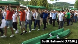 A srebrenicai népirtás ötven áldozatának maradványait tartalmazó koporsókat viszik Potočariban, Bosznia-Hercegovinában 2022. július 10-én