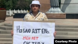 Сайлау заңына түзетулерге қарсы шыққан Алматы тұрғыны Данияр Супиев жалғыз адамдық пикет өткізіп тұр. 24 шілде 2022 жыл. Сурет авторы Әйгерім Тілеубаева.