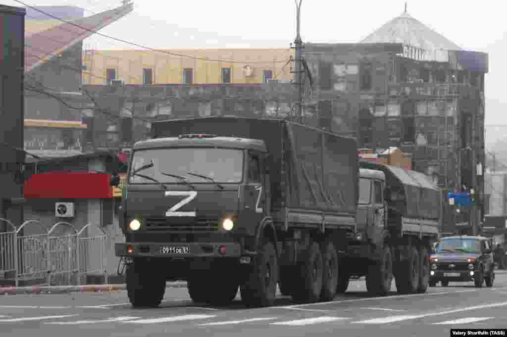 На этой фотографии, сделанной 19 октября, видны российские военные грузовики на фоне сгоревших зданий в центре Мариуполя. 